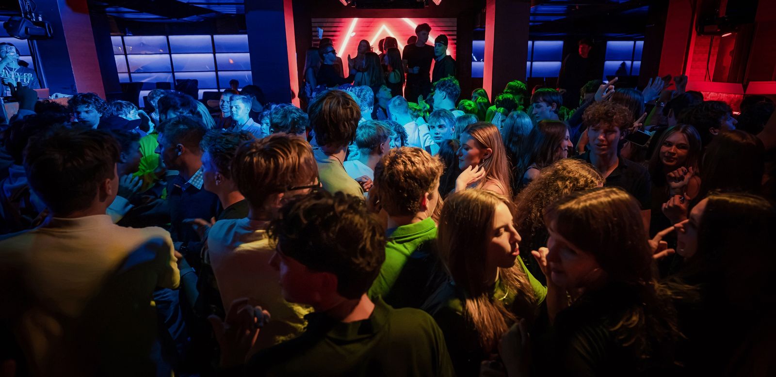 Pełny parkiet na imprezie HYPE PARTY, ręce w górze, niebieskie i zielone światła